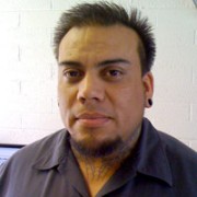 Jerry Shaw Man with short, spiky dark hair, a goatee, and neck tattoos